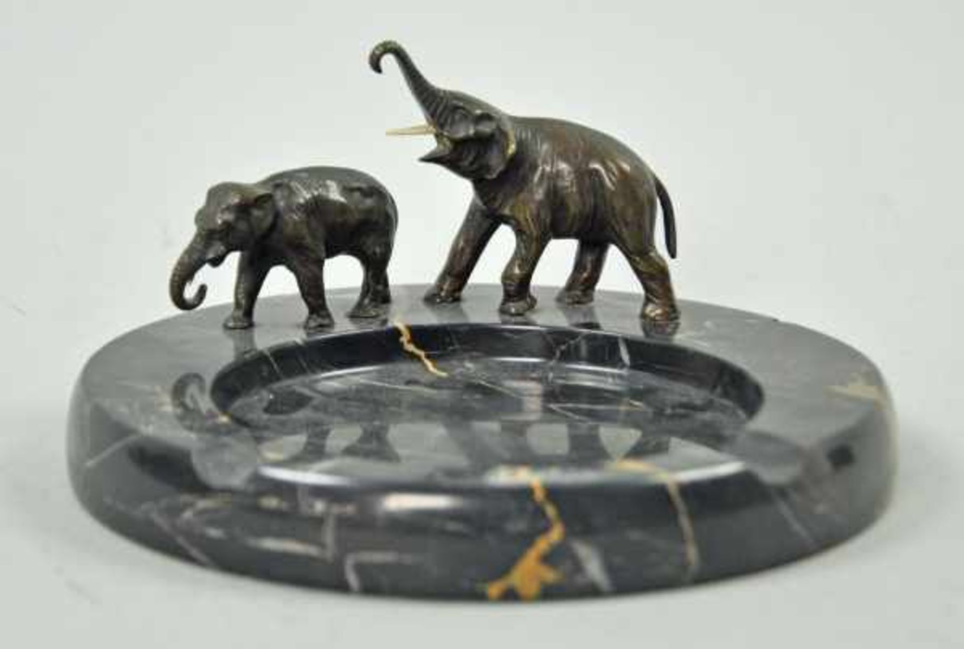 ASCHENBECHER rund, schwarzer Marmor, mit zwei Elefanten(je ein Stoßzahn fehlend), Bronze, H 9,5cm, D