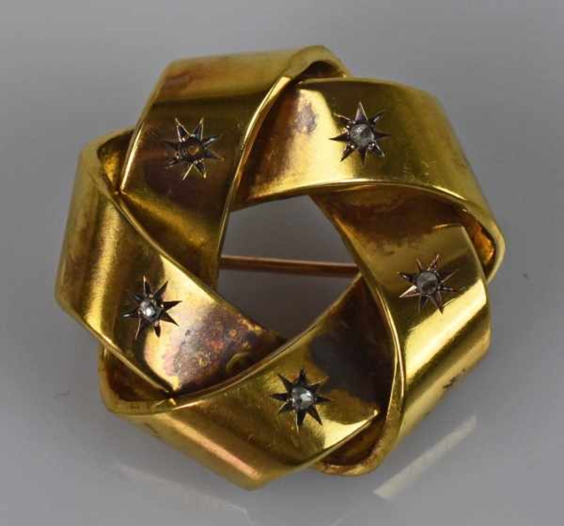 BROSCHE rund geflochtenes, breites Band besetzt mit 5 kleinen Diamanten in sternförmiger Fassung,
