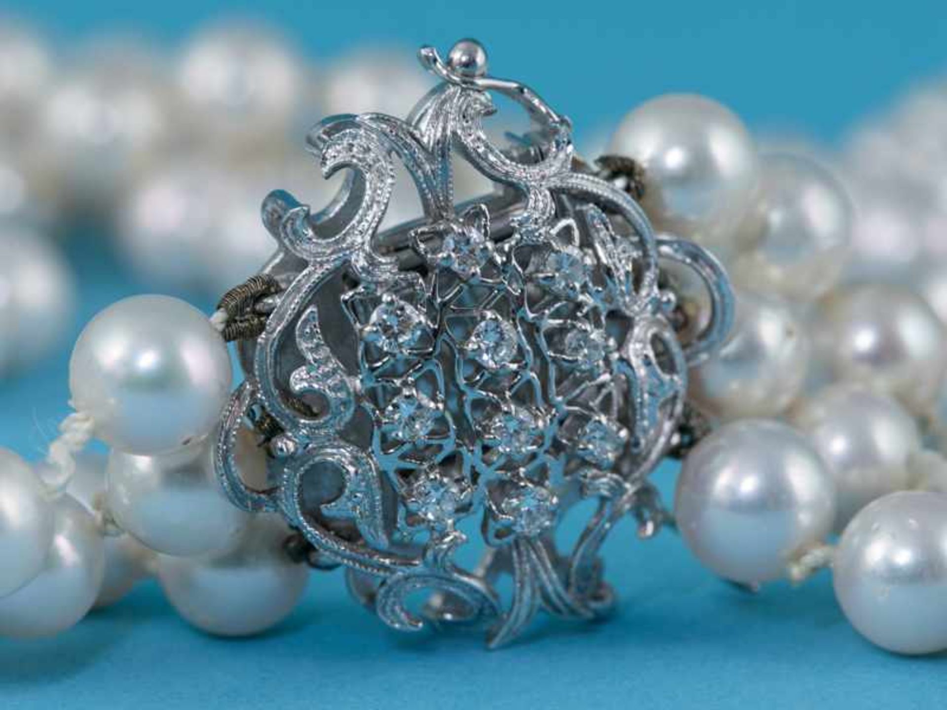 3 rhg. Akoja-Perlenkette mit 10 Brillanten besetzte Schließe, zusammen ca. 0,3 ct, 70- Jahre 750/-
