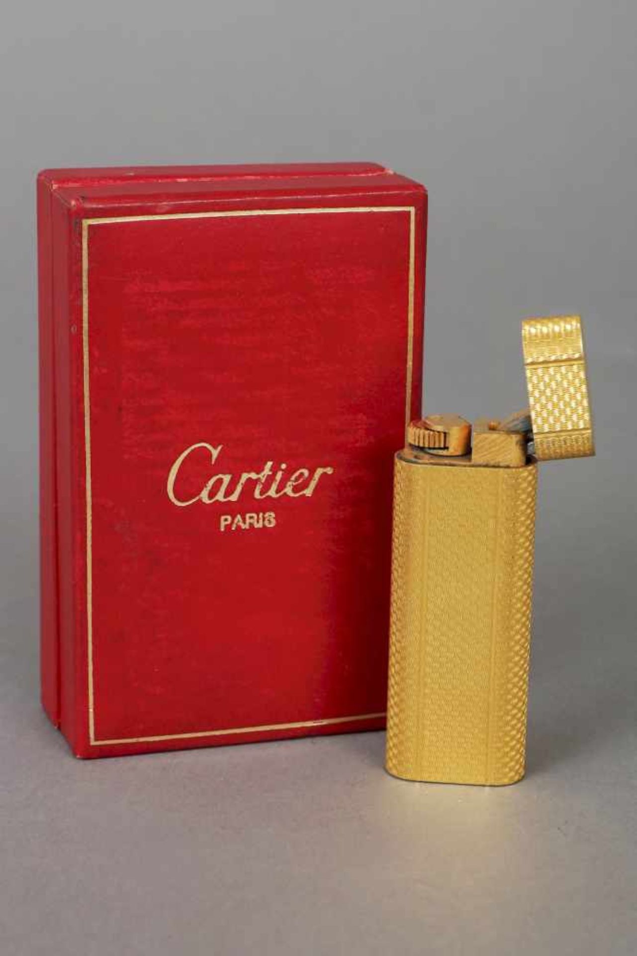 CARTIER FeuerzeugMetall, vergoldet, hochrechteckige Form, fein punziert, Nr. 61902, H 7cm, in