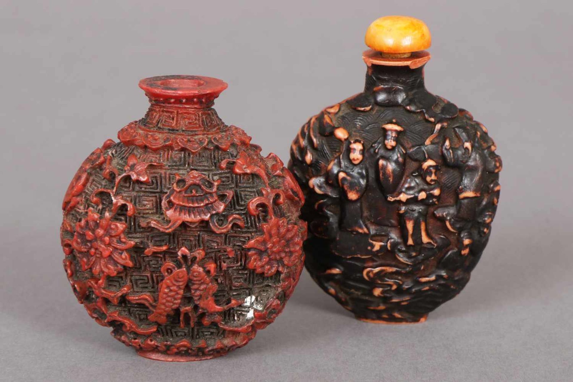 Paar chinesische Snuff-bottlesLack, 1x dunkel patiniert mit Reliefdekor ¨Handelsszene¨, 1x