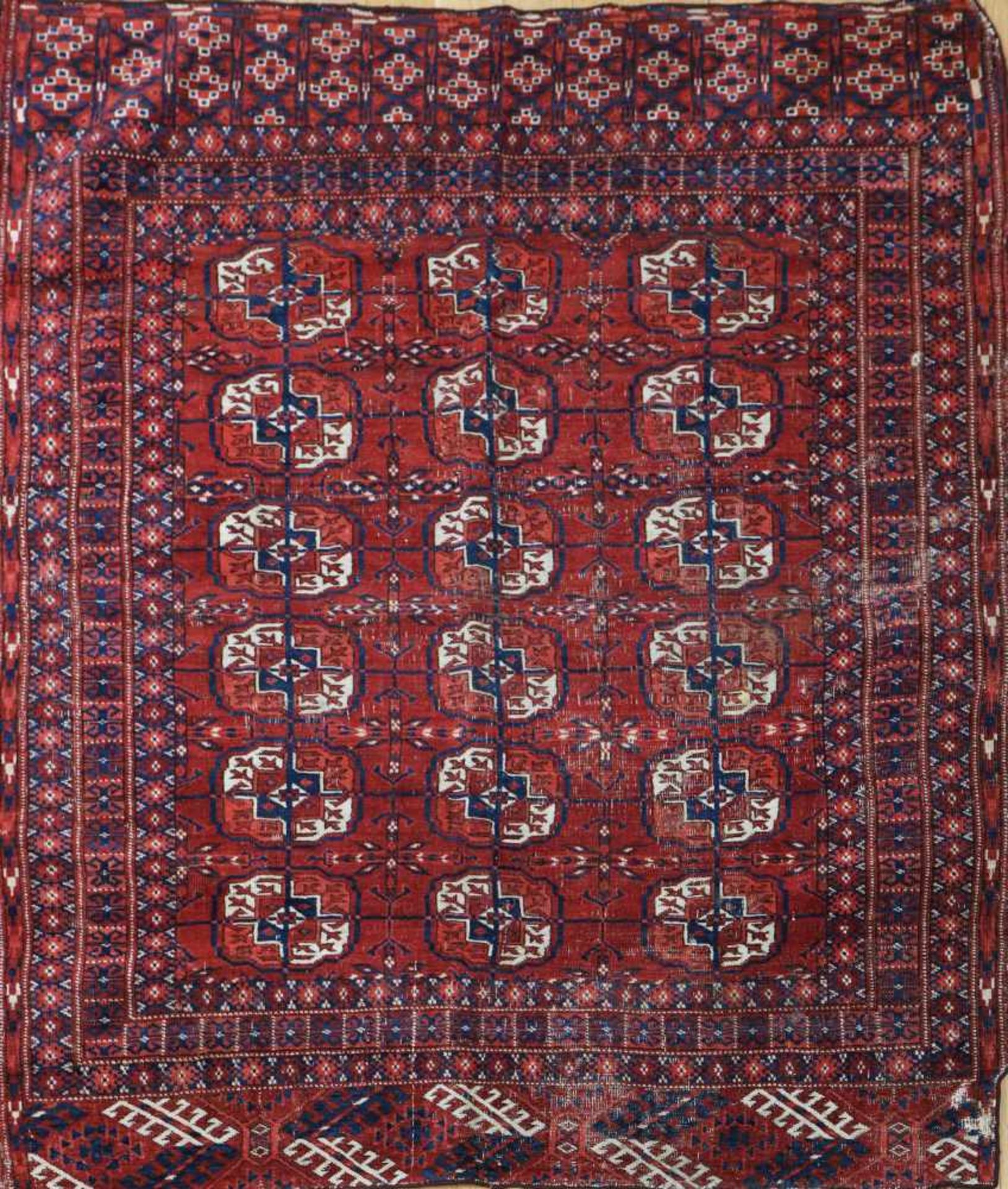 Turkmenischer Teppich, ¨Tekke¨rotgrundig, stilisiertes Dekor, um 1900, ca. 130x106 cm, Lichtschäden,