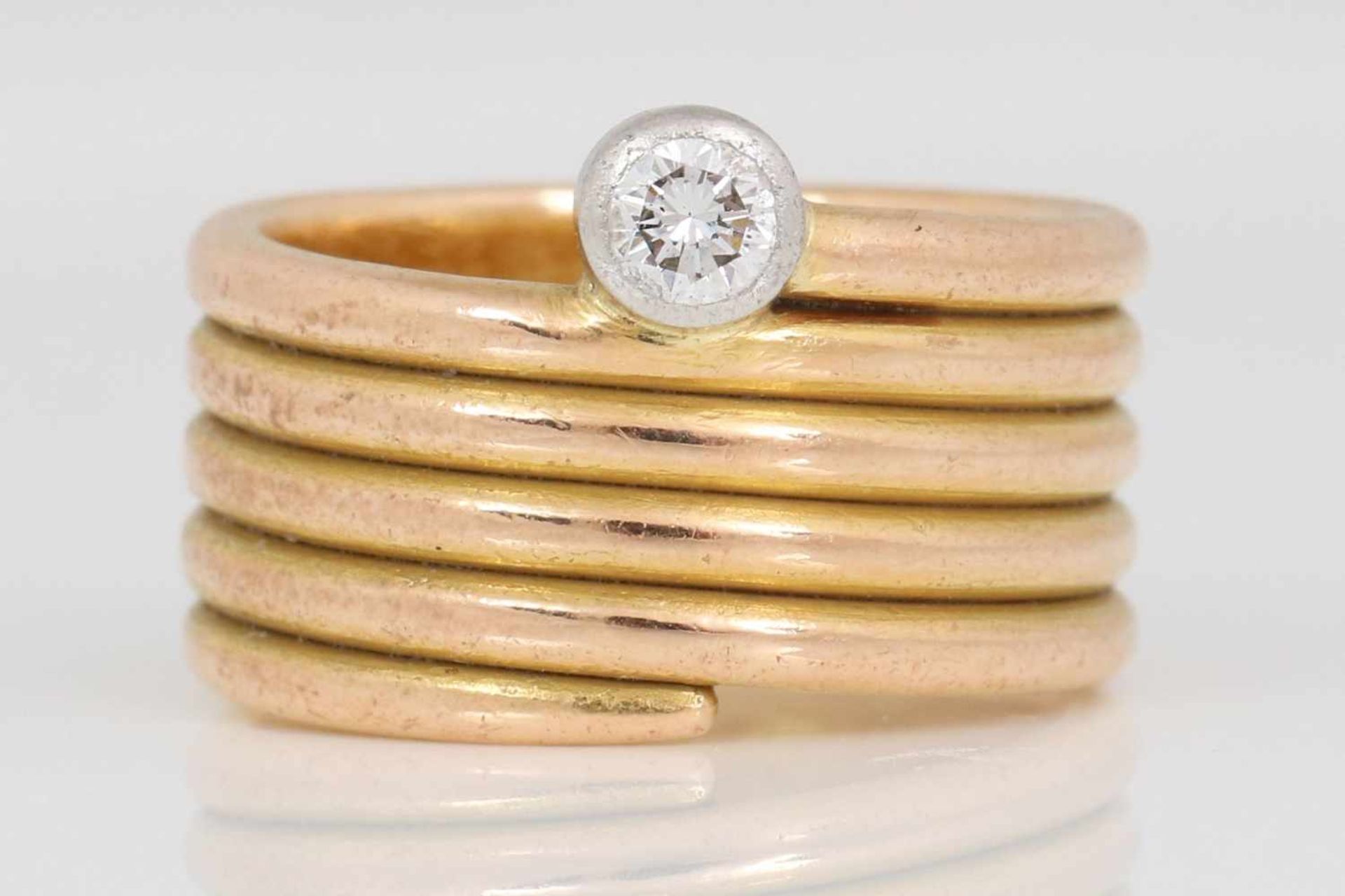 Goldring mit DiamantRoségold, spiralförmige, breite Schiene, 1 Brillant, ca. 0,15ct., vsi, Gewicht