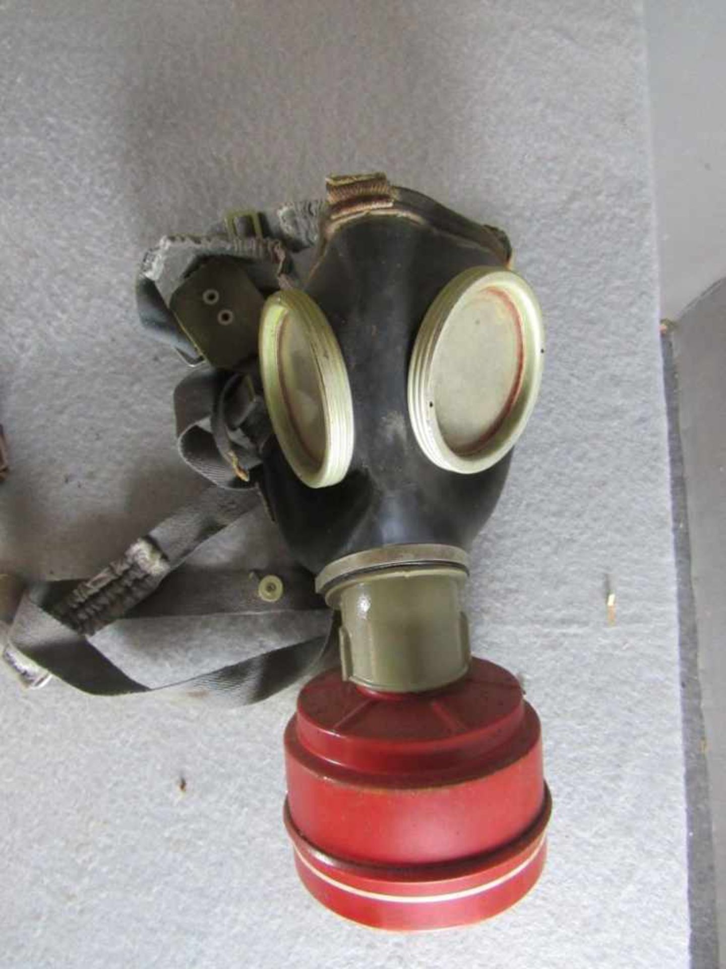 Vierteiliges Militaria-Konvolut Gasmaskendose mit Maske 1x MP Magazin 2x Stahlhelmglocken - Bild 2 aus 5