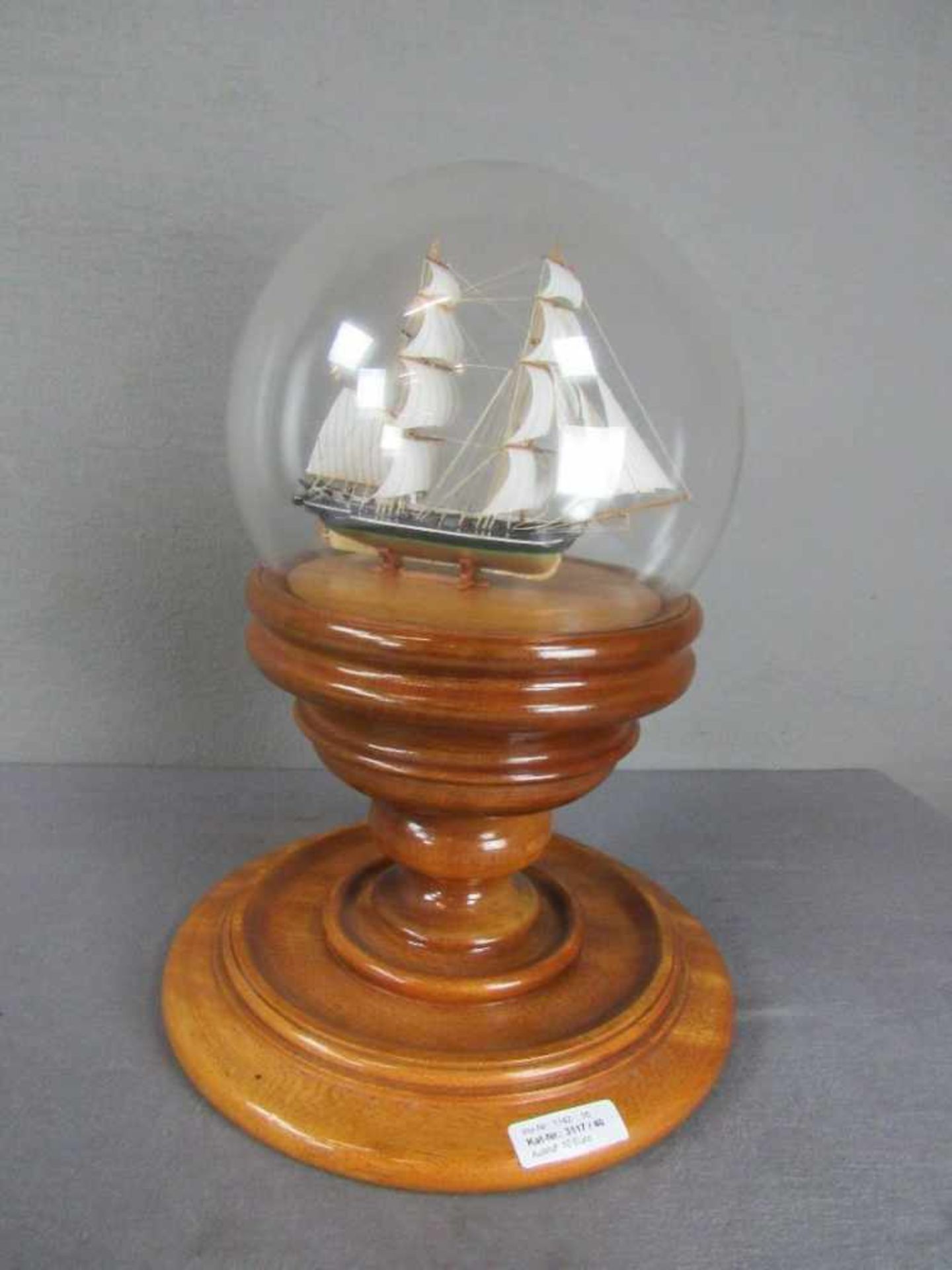 Modellschiff unter Glaskugel auf schwerem Holzsockel Höhe ca.42 cm