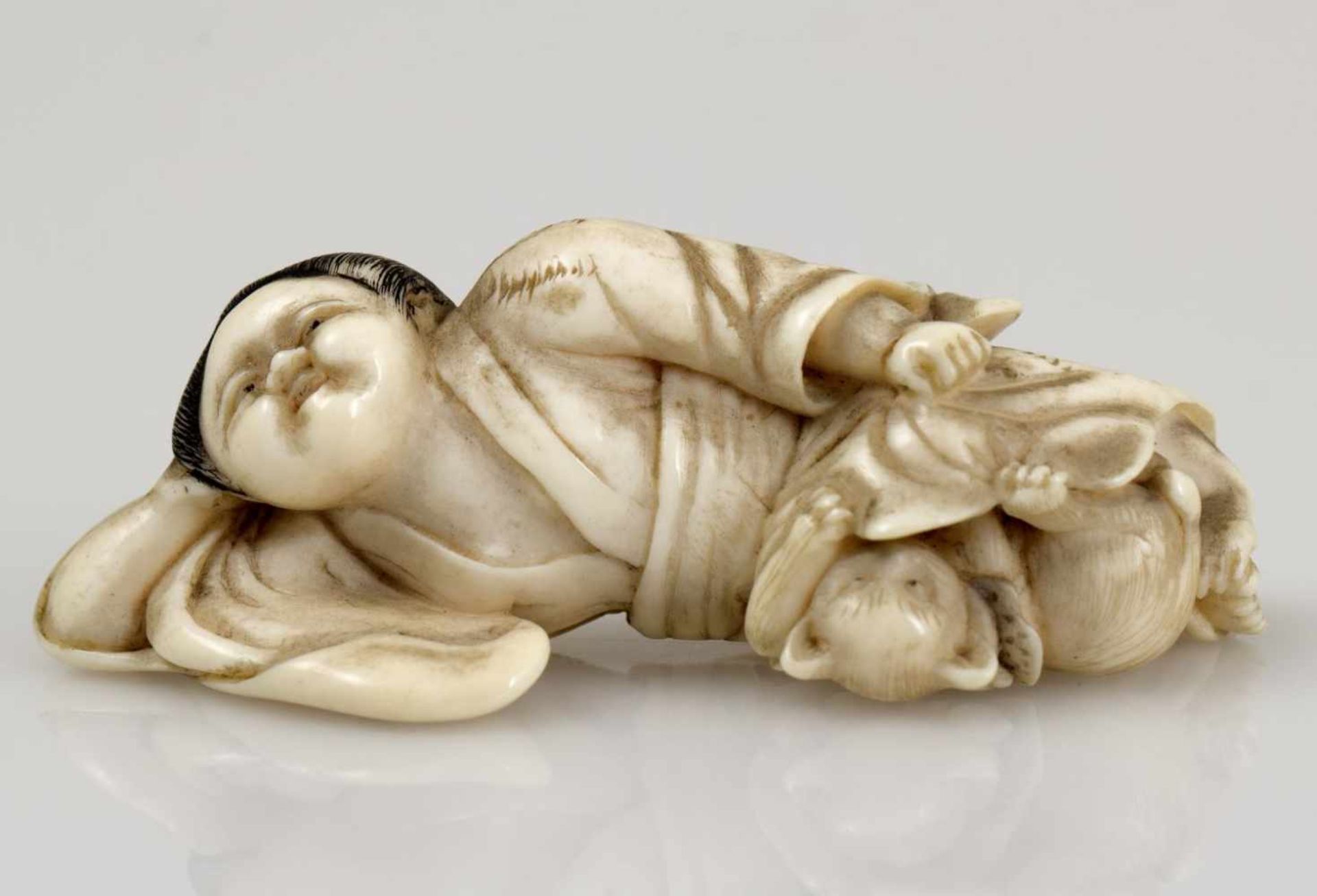 Netsuke ruhende Okame mit KatzeElfenbein. Japan, spätes 19. Jh. L. 5 cm. Bitte beachten Sie, dass