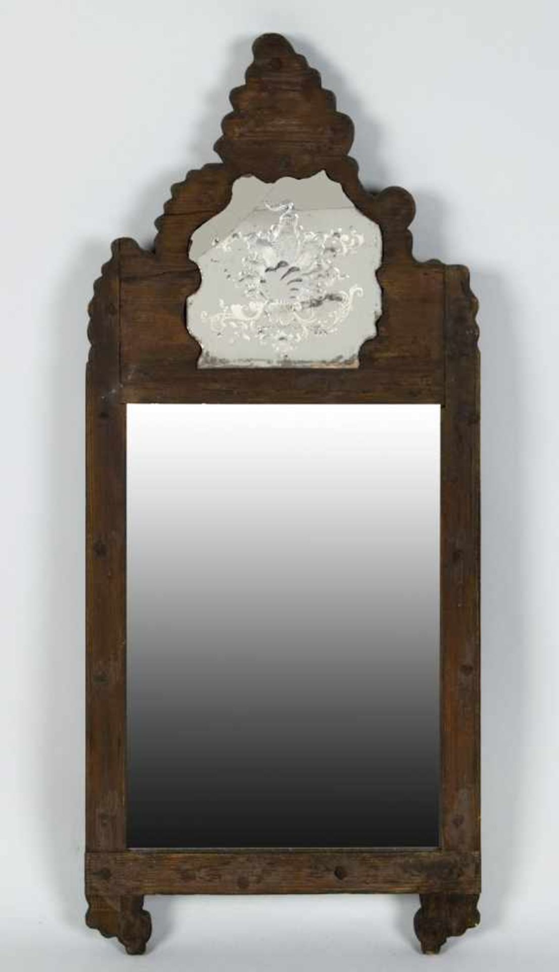 WandspiegelNadelholz, dunkel gebeizt. Untere Scheibe facettiert, obere mit Ätzdekor. 88 x 39 cm.
