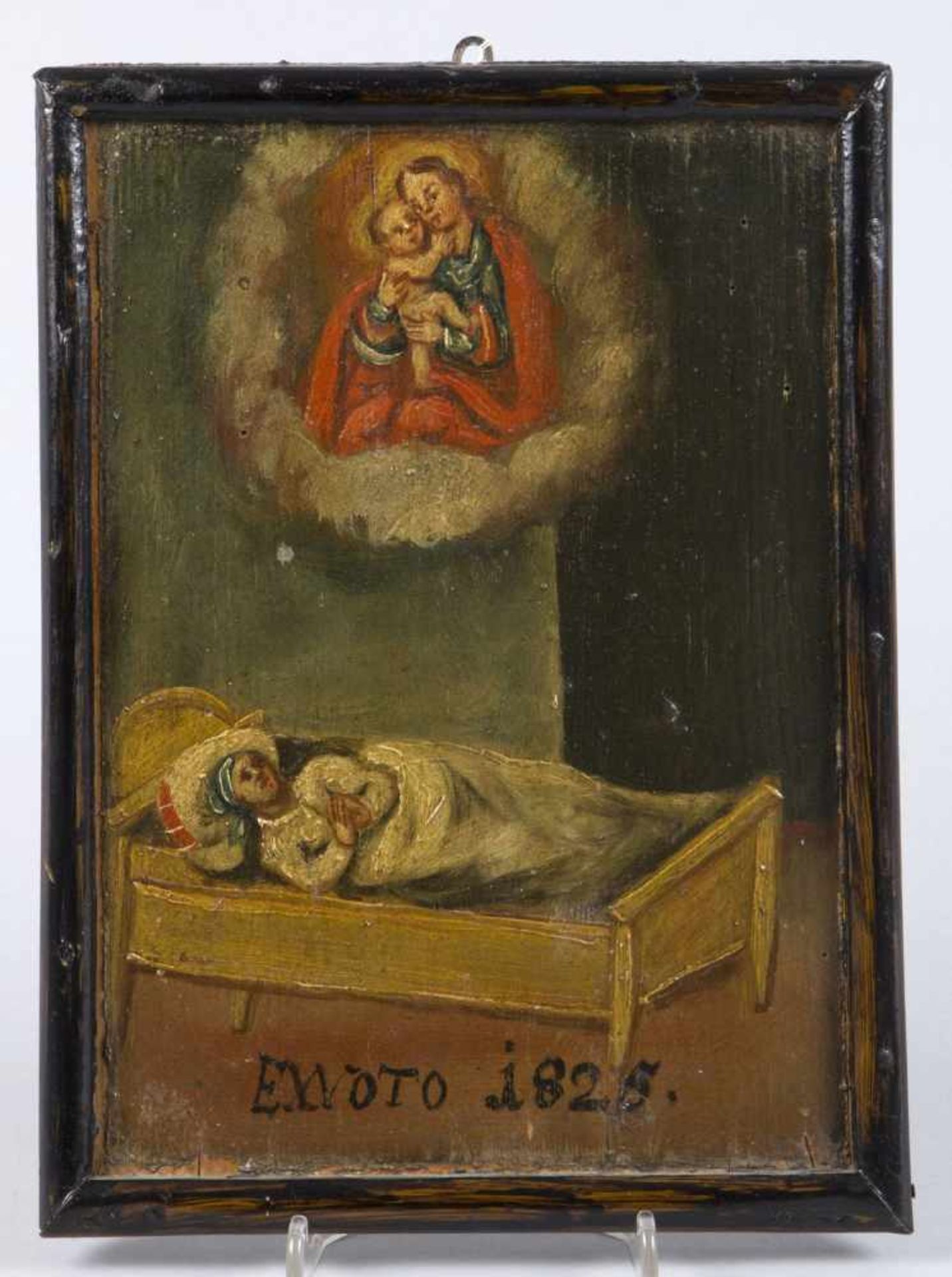 VotivbildTempera auf Holz. Kranke im Bett und Maria mit Kind im Wolkensaum. Bez. Ex Voto 1825.