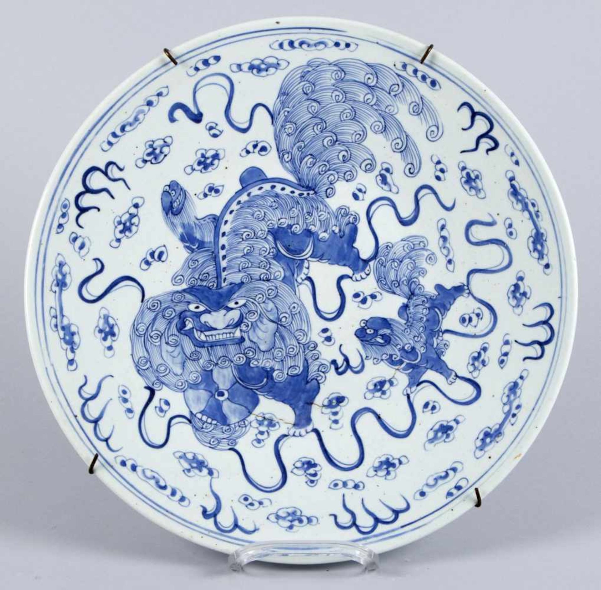 PlattePorzellan. Blauer Dekor mit Fo-Hunden. China. D. 37 cm. Brandrisse.- - -27.00 % buyer's