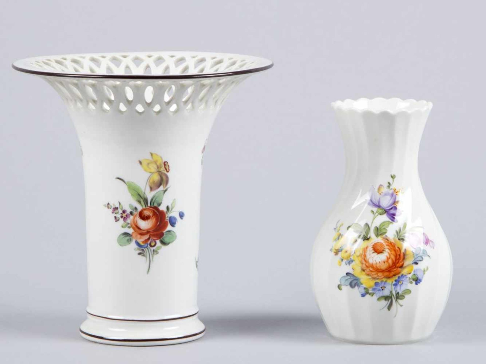 Zwei VasenPolychrome florale Bemalung. Versch. Formen und Dekore. Marke: Nymphenburg. H. bis 15 cm.-