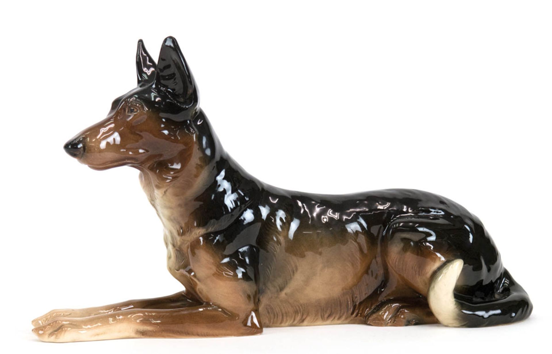 Porzellanfigur "Liegender Schäferhund", gemarkt "Hertwig", am Ohr leicht best., L. 36 cm,H. 21 cm