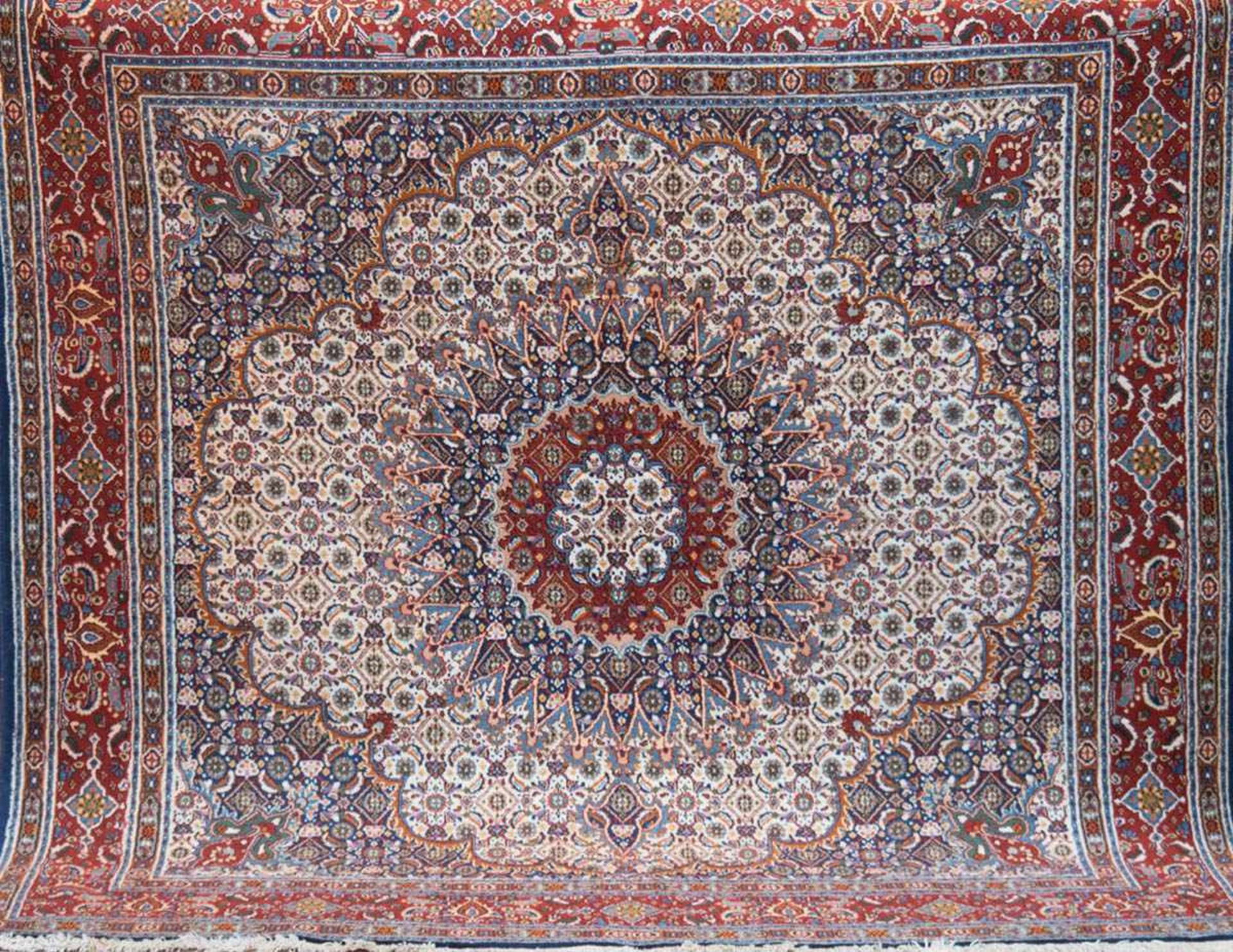 Maud-Persien, rotgrundig mit zentralem Meadillon und floralen Motiven, leicht fleckig,200x200 cm