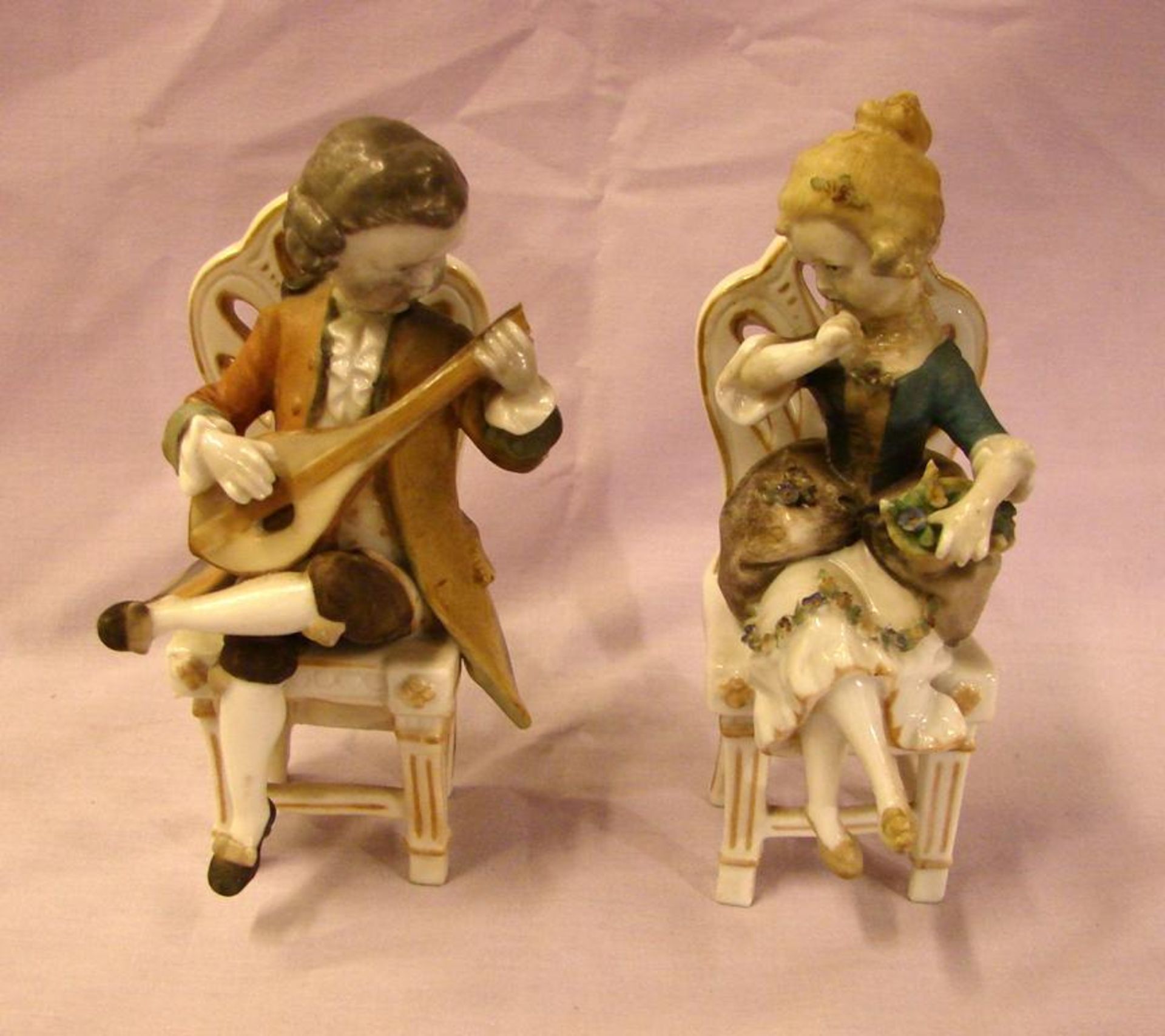 Paar Porzellanfiguren, sitzend auf Stuhl, ohne Marke, H. ca. 14 cm