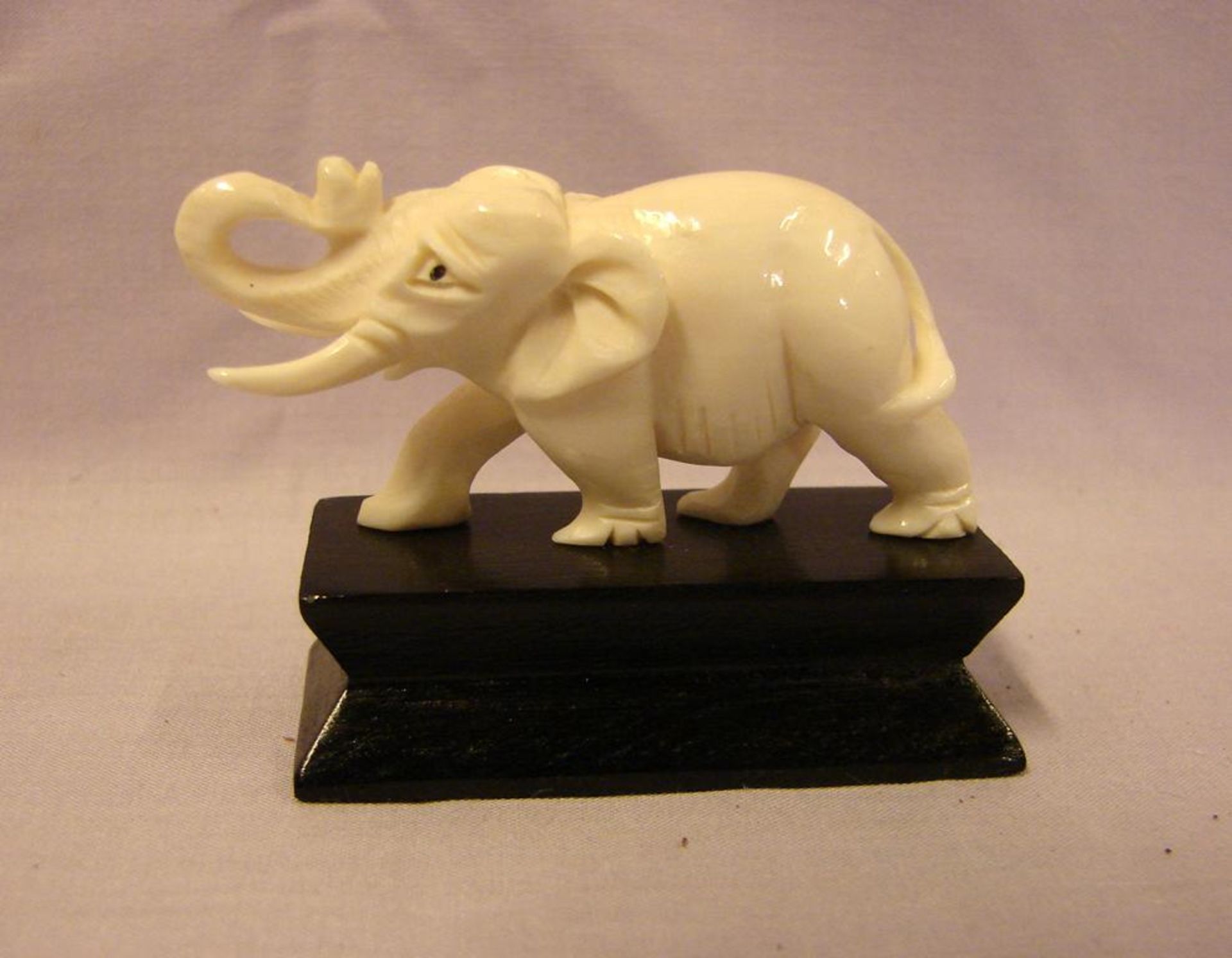 Elefant, Bein, geschnitzt, auf Holzsockel, H. ca. 4, B. 5,5 cm