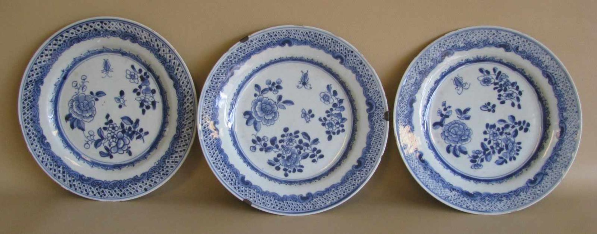 3 antike Teller, China, Porzellan mit unterglasurblauer Blütenmalerei, Chips am Rand, d 23,5 cm.
