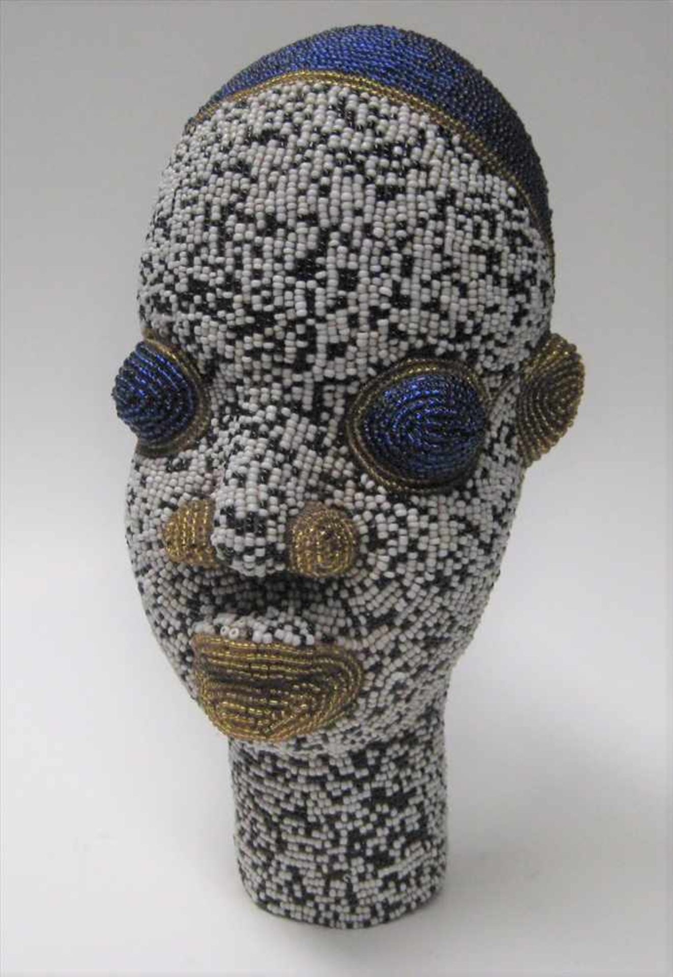 Kopf einer Afrikanerin, Ton geformt, umlaufender, farbiger Glasperlenbesatz, h 25 cm, d 14 cm.