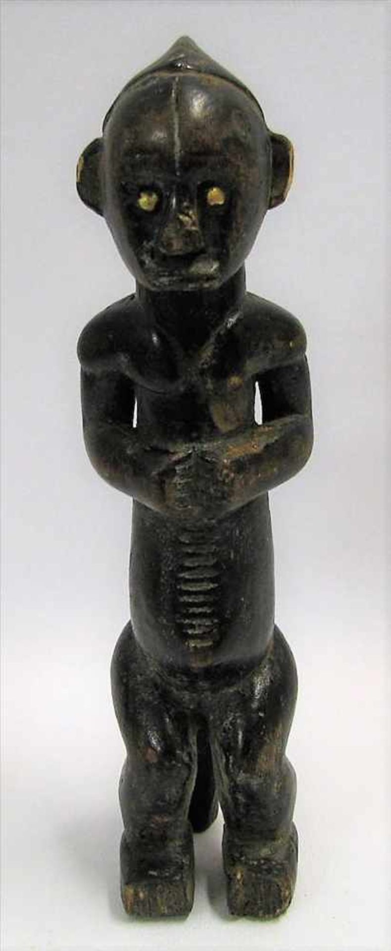 Männliche Figur, Afrika, wohl Bembe/Kongo, Holz beschnitzt, Messingaugen, 22 x 5 x 5,5 cm.