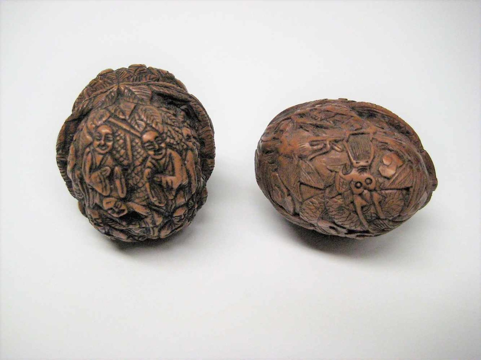 2 beschnitzte Walnüsse, China, d 3,5/4 cm.
