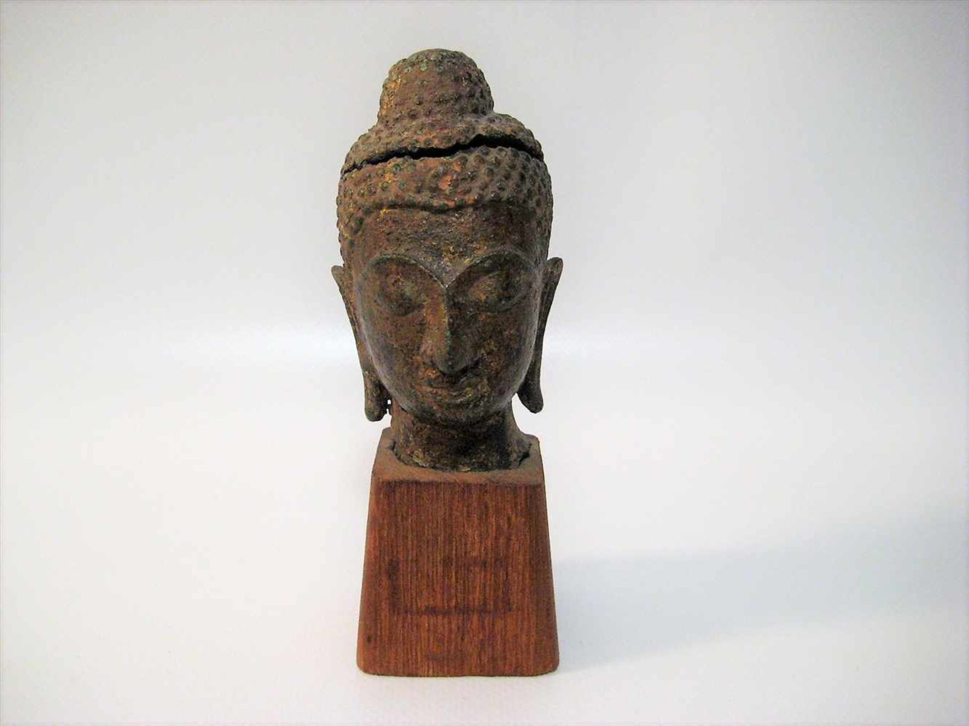 Kopf eines Buddhas, Thailand, Bronze, Kopf besch., Holzsockel, 9 x 5 x 5,5 cm.