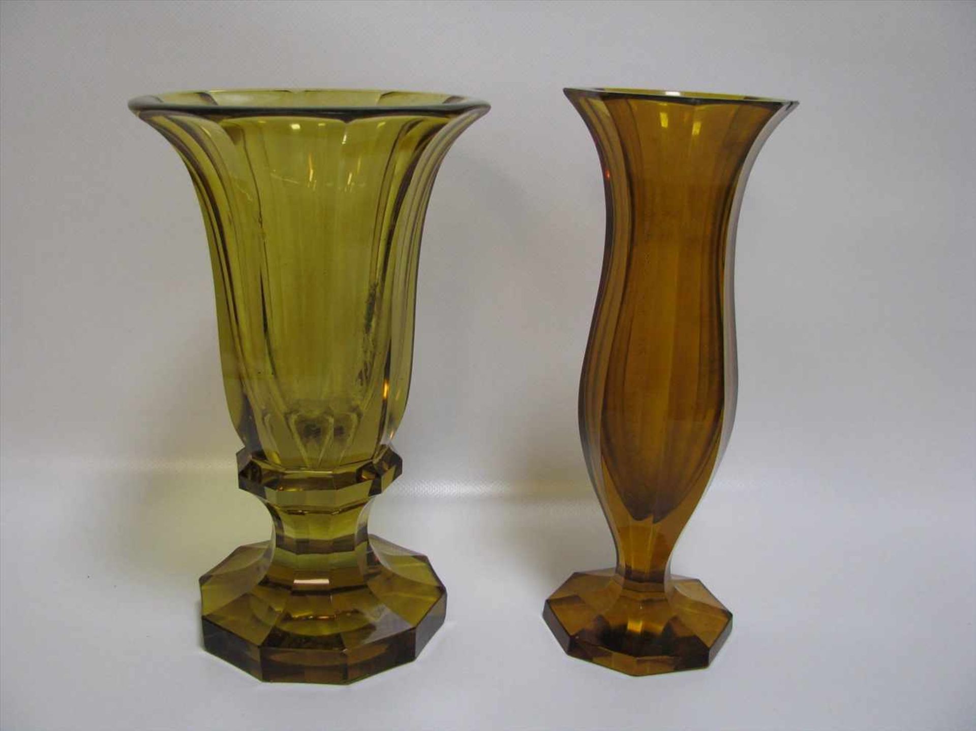 2 Vasen, wohl Österreich, bernsteinfarbenes Bleikristall, kantig beschliffen, best., h 23,1/24 cm, d