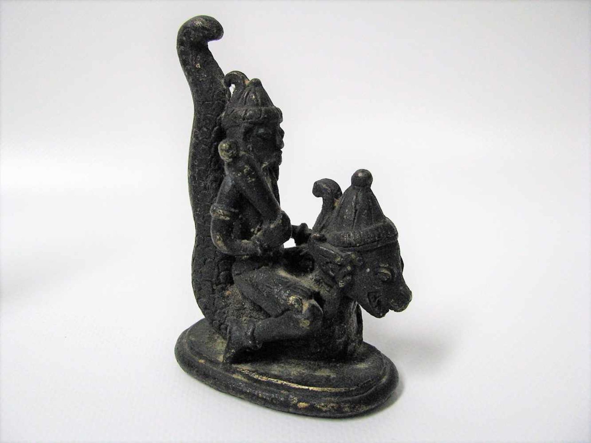Sitzende Gottheit auf Wassertier, Tibet/Nepal, Bronze, 10 x 4 x 7 cm.