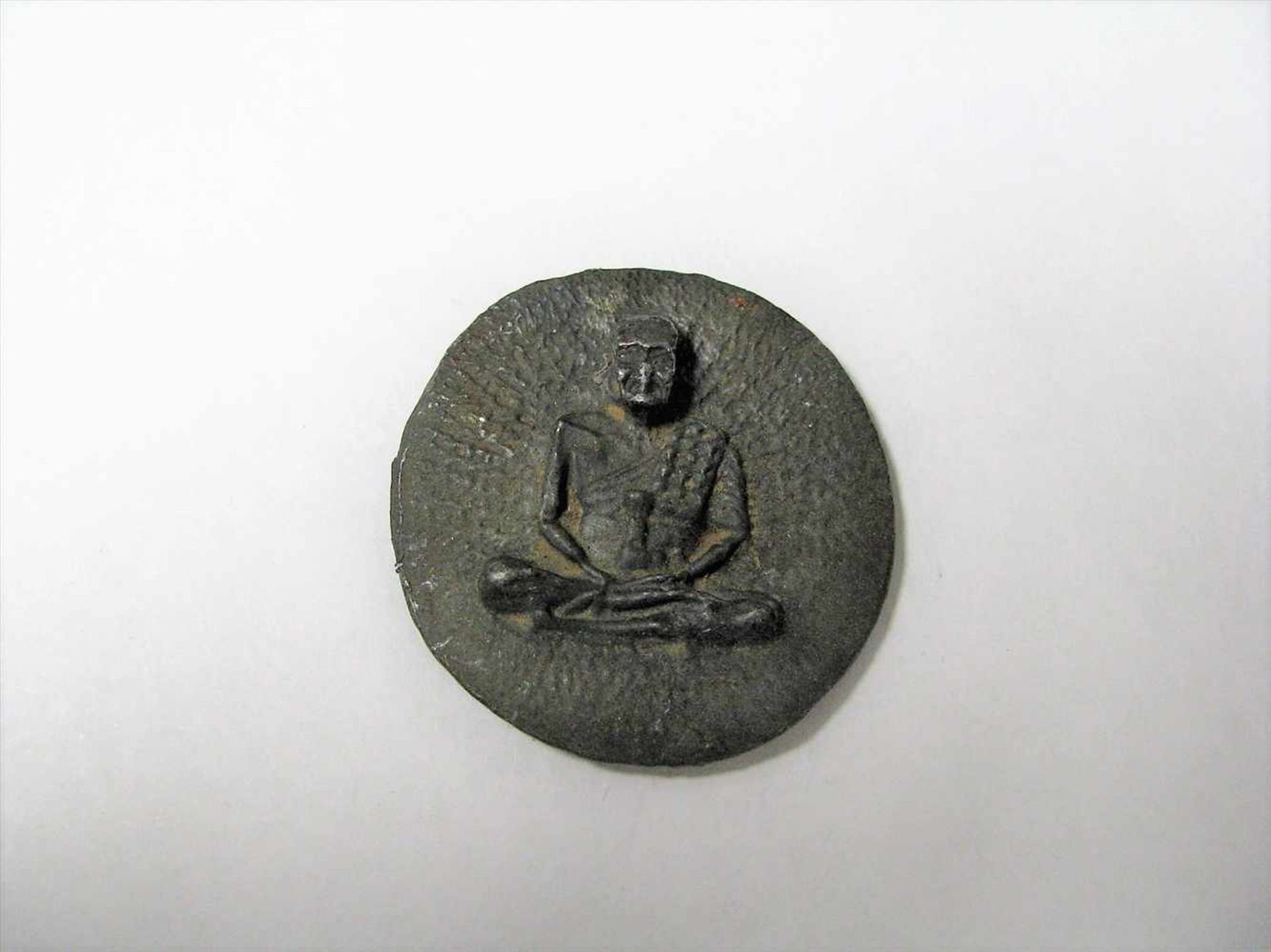 Runde Plakette mit Reliefabbildung eines seitzenden Mönchs, Tibet/Nepal, Zinn, d 4,5 cm.