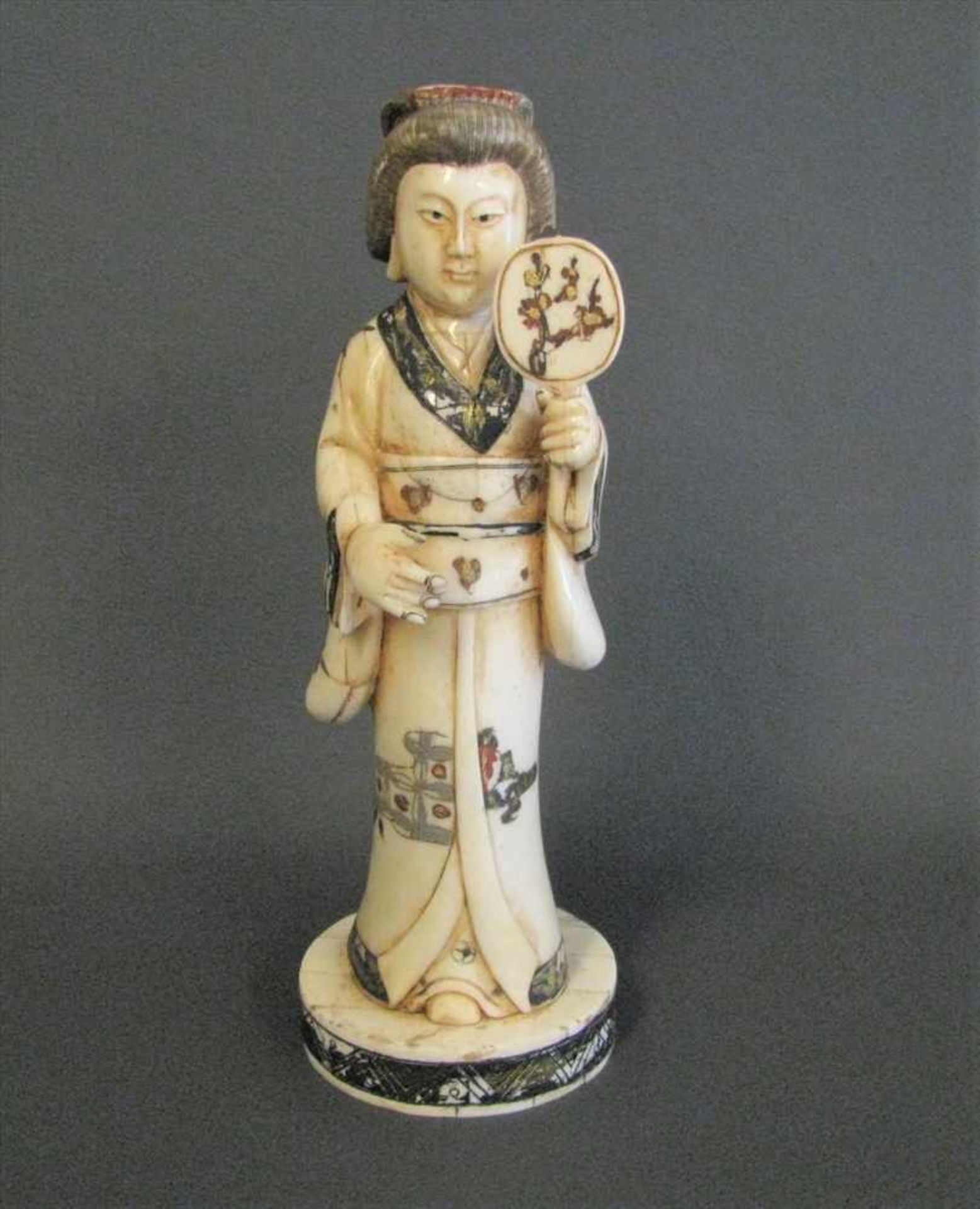 Geisha, Japan, Bein beschnitzt, polychrom bemalt, sign., h 21,5 cm, d 7 cm.