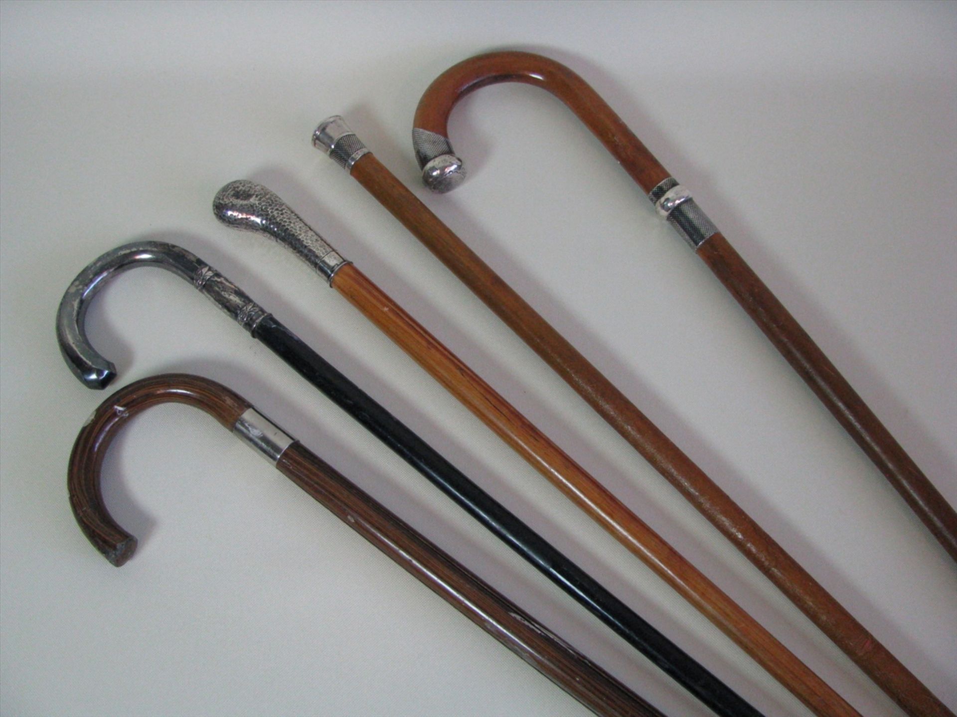 5 diverse Spazierstöcke, um 1900, 4 x mit Silbergriffen, ca. l 91 cm.- - -19.00 % buyer's premium on