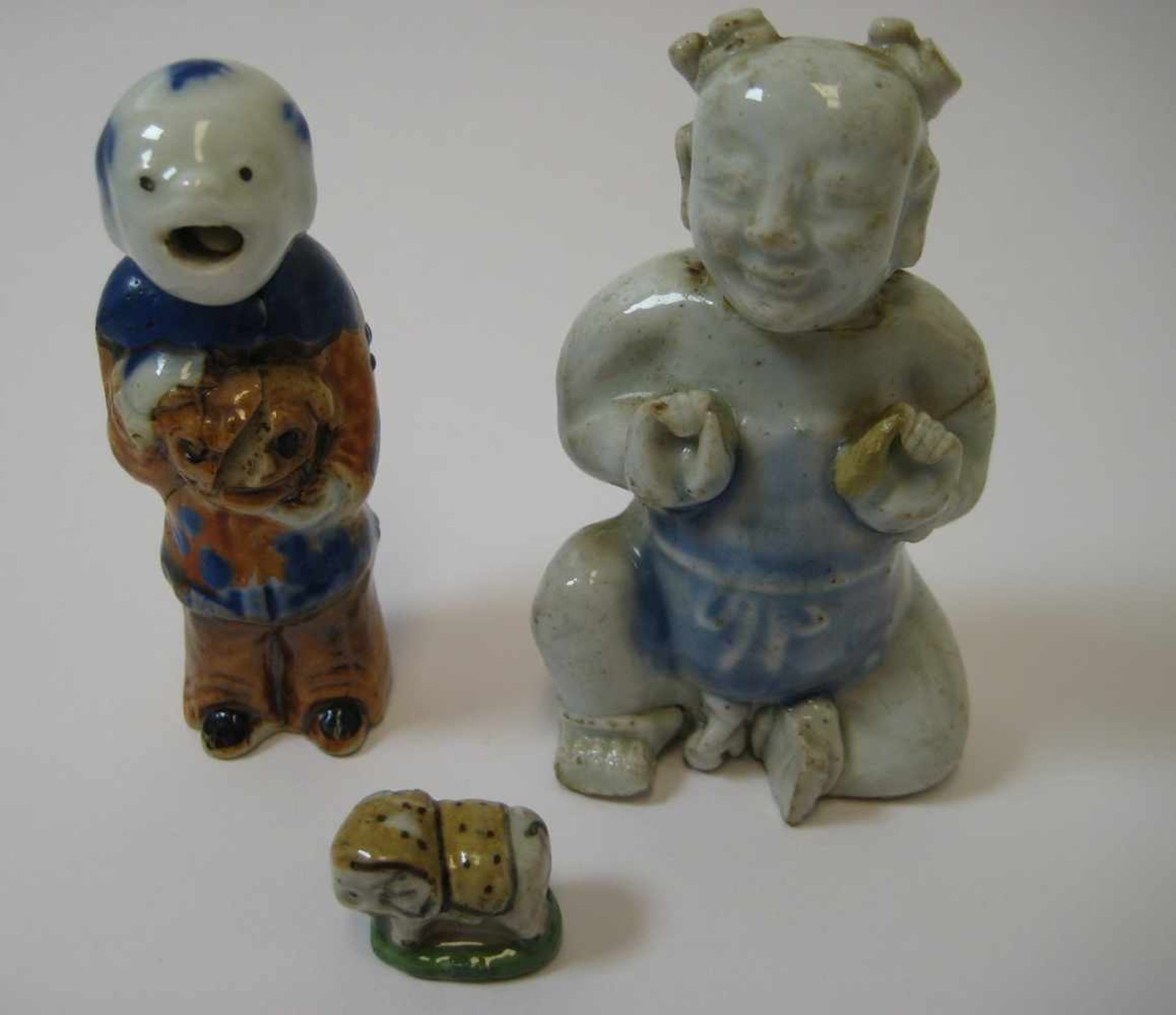 3 Porzellanfiguren, China, antik, Porzellan mit polychromer Bemalung, rest., h 1,2/7,5/8 cm.- - -