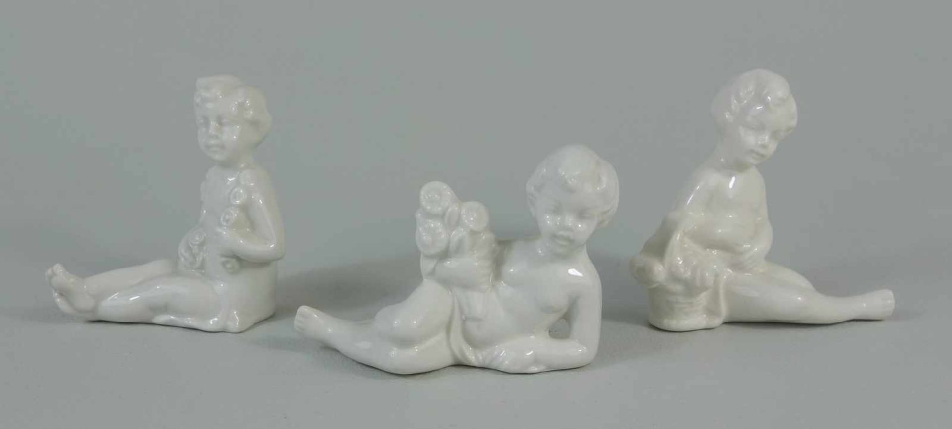 3 kleine Putten, Porzellanohne Herstellermarke, weiß glasiert, H.von 5 bis 6cm, L.6-7cm
