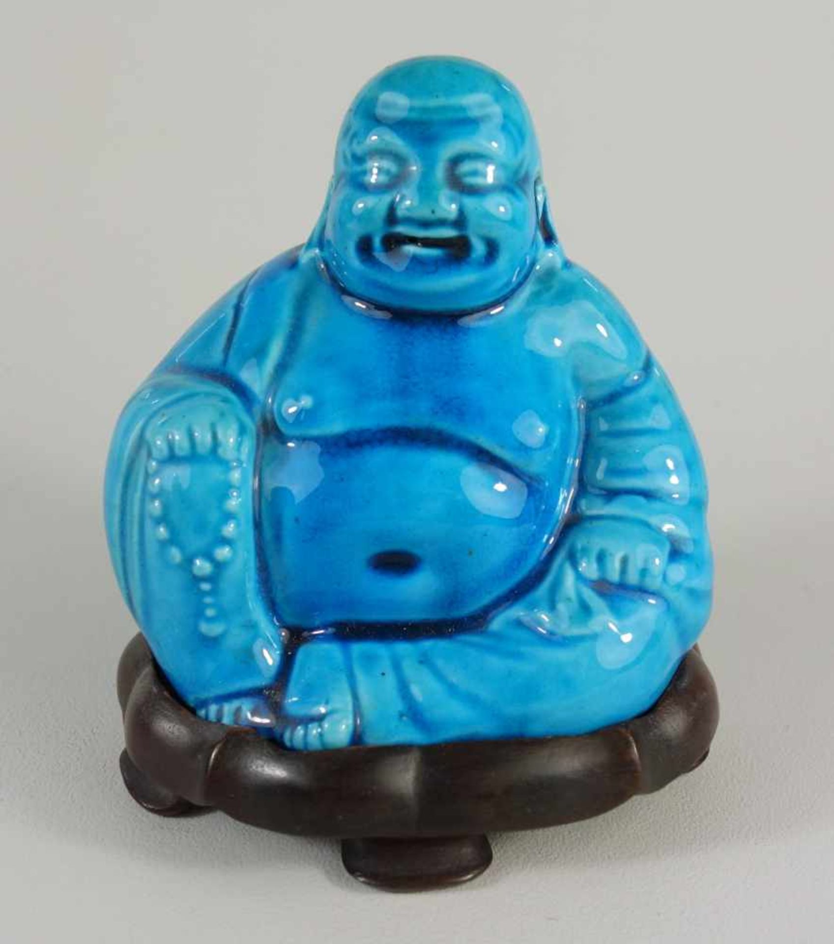 dicker, lachender Buddha auf Holzsockel, 20.Jh.Keramik, blau glasiert, H.mit Sockel 13,5cm
