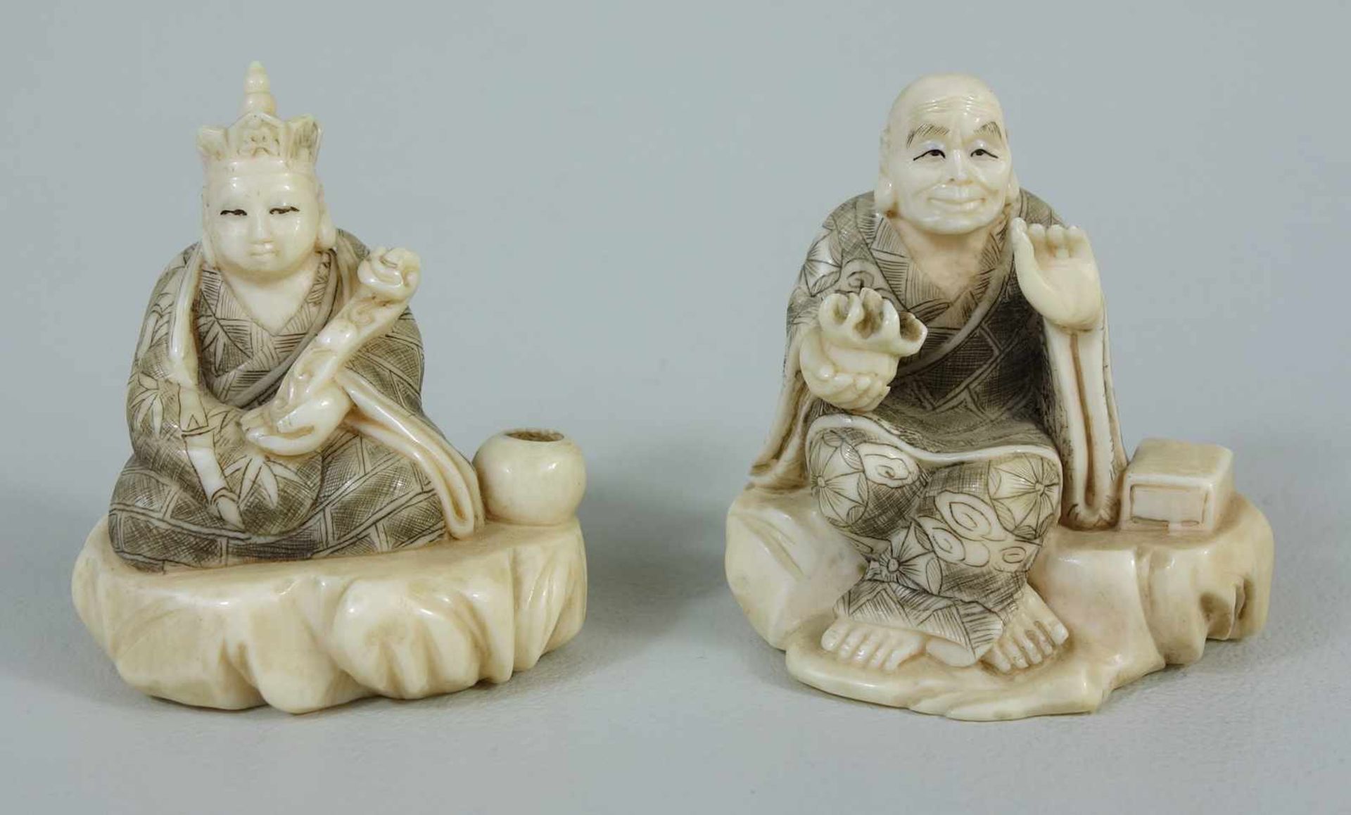 zwei Okimono, Japan, um 1900-1920, Gelehrtenfiguren mit Attributen, Elfenbein geschnitzt, Gewand mit