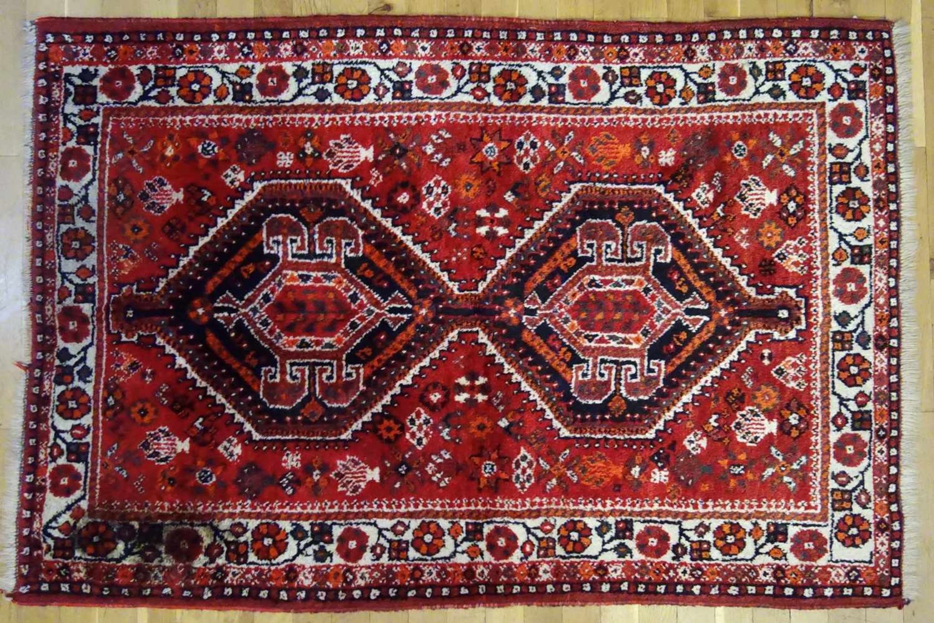 kleiner Teppich mit Blumenbordüre, ca.162*108cm, weinroter Grund, 2 große Medaillons, eine Ecke