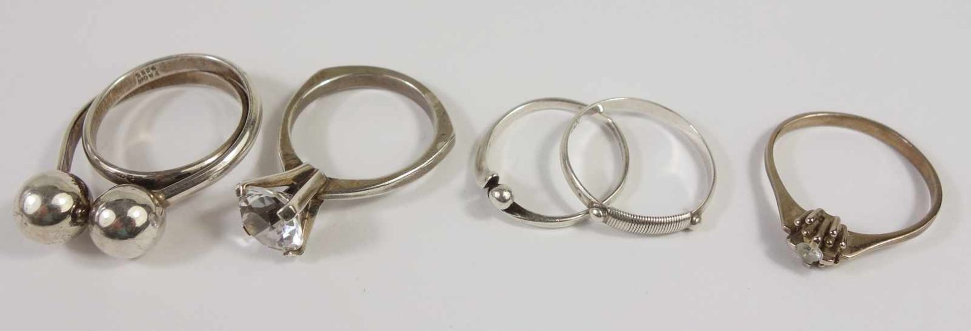 4 silberne Ringe und ein Ring, 333er Gold, Silber-Gew.10,71g, unterschiedliche Arten und Größen, U.