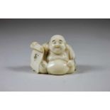 Netsuke, Japan, Bein, lachender Buddha mit offener Schriftrolle, vollplastisch geschnitzte