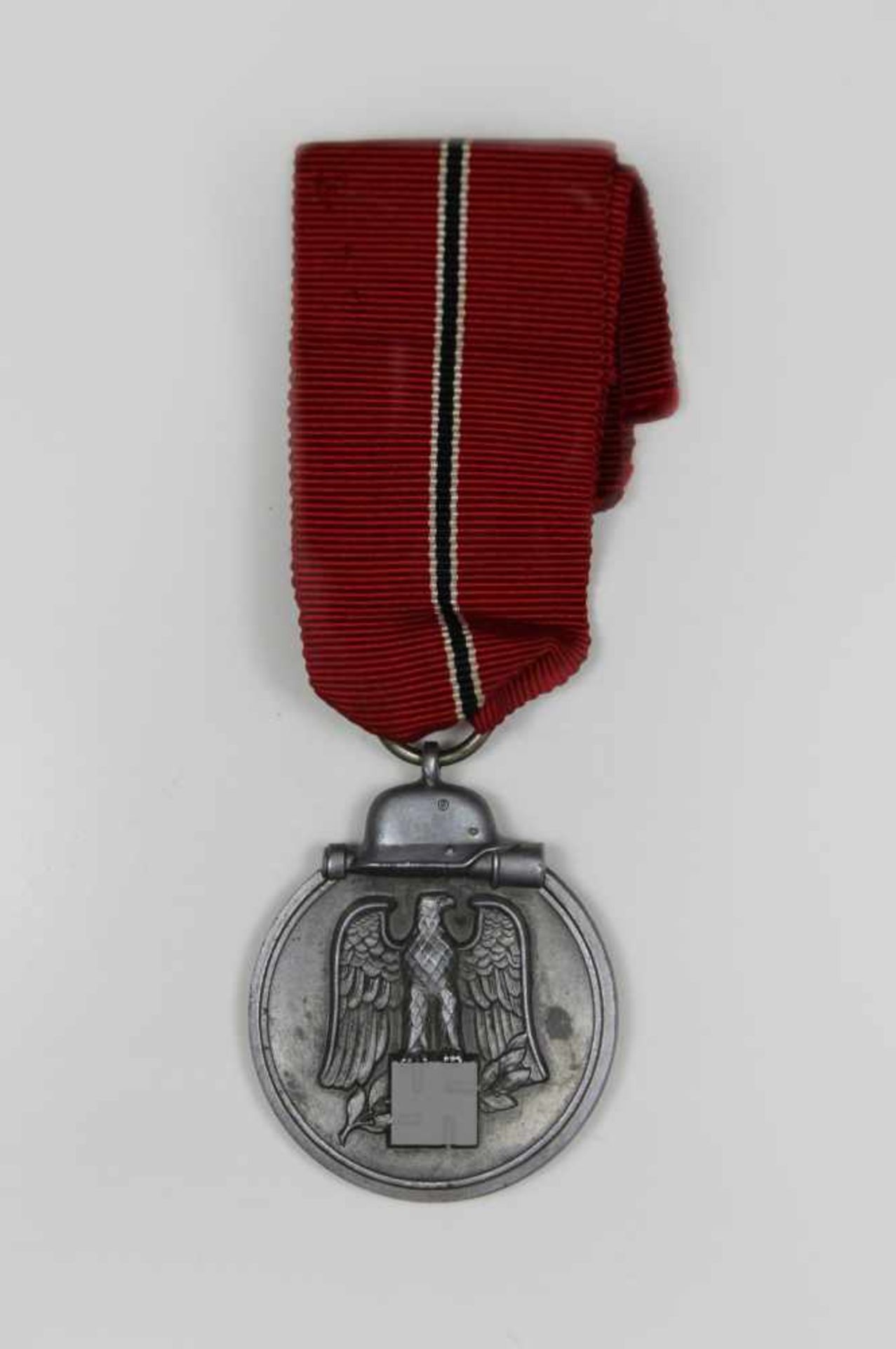 Ostmedaille mit rotem Ordensband (mit schnalem Streifen weiß/schwarz/weiß), Avers mit Reichsadler