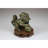 Fo-Hund, China 19. Jh., Bronze, sitzend mit rechtem Vorderbein auf Kugel, H.: 11,5 cm.