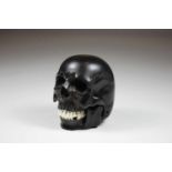 Totenkopf aus Ebenholz, geschnitzt, Holz und Bein, D.: ca. 7 cm.