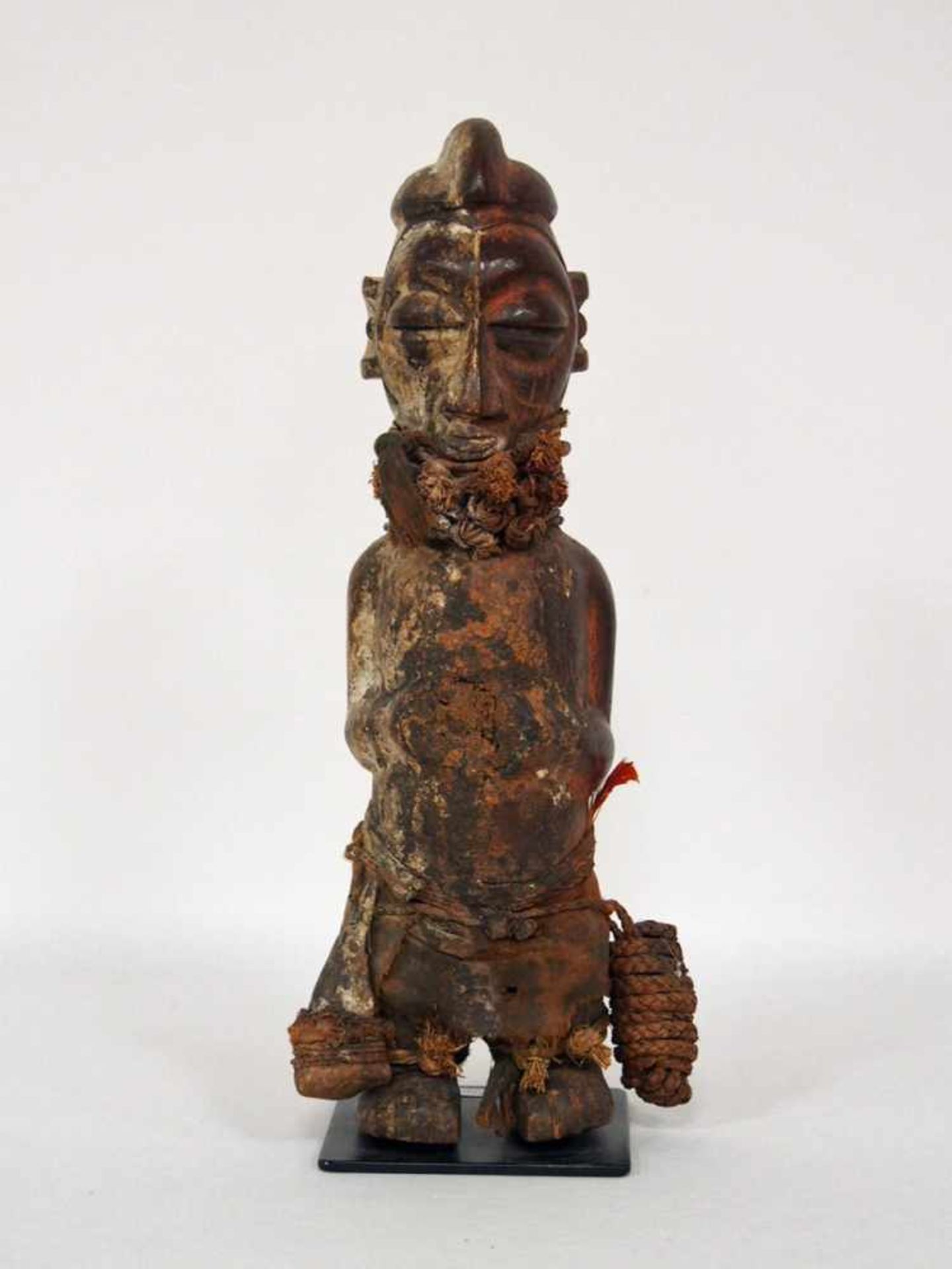 Statue eines MannesHolz, vollrund geschnitzt, farbig gefasst, Bast, gefärbtes Leinen, Yaka, Kongo,