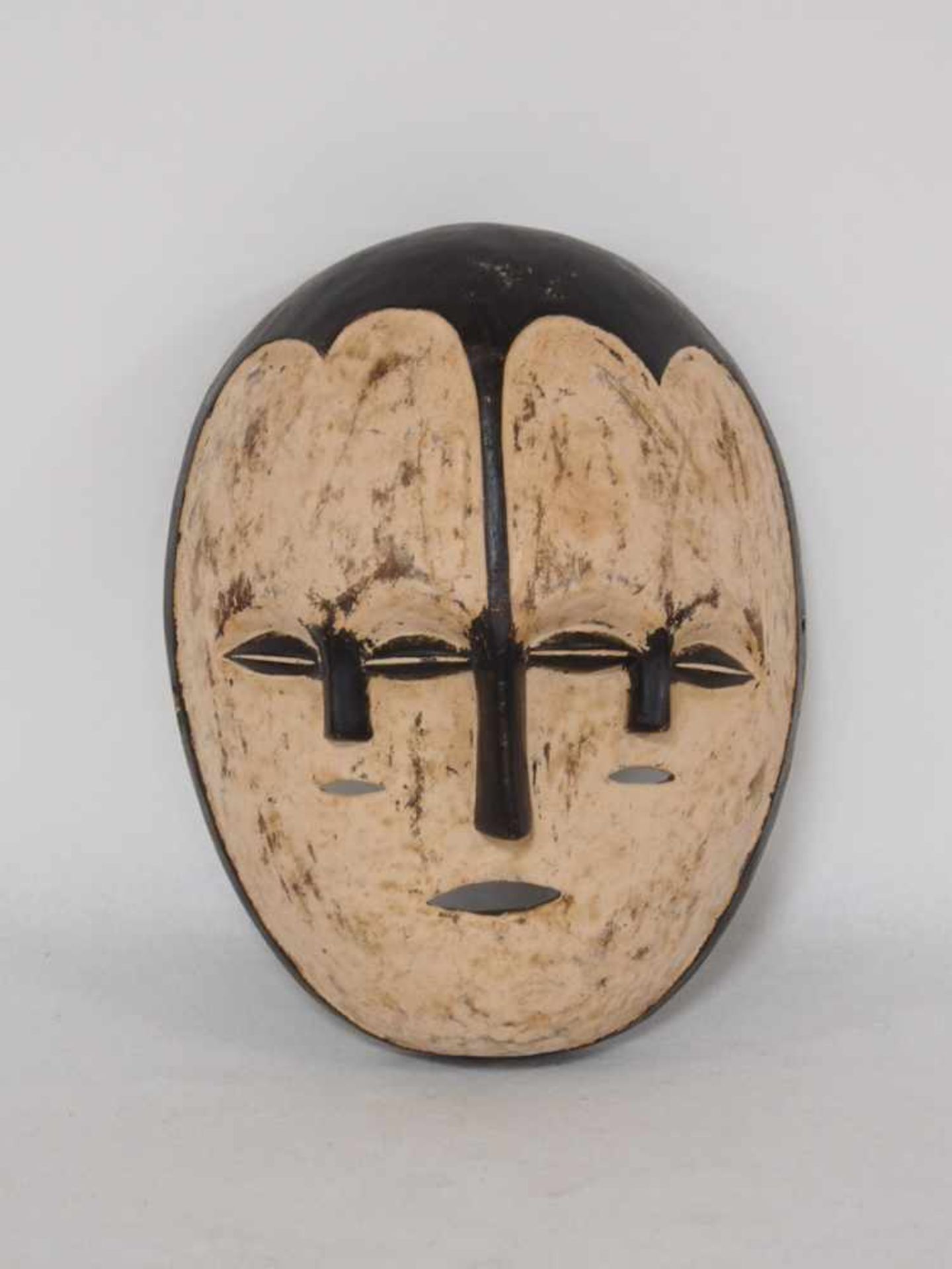 Dreigesichtige MaskeHolz, geschnitzt, weiss, schwarz gefasst, Westafrika 20. Jahrhundert, Höhe 31 cm