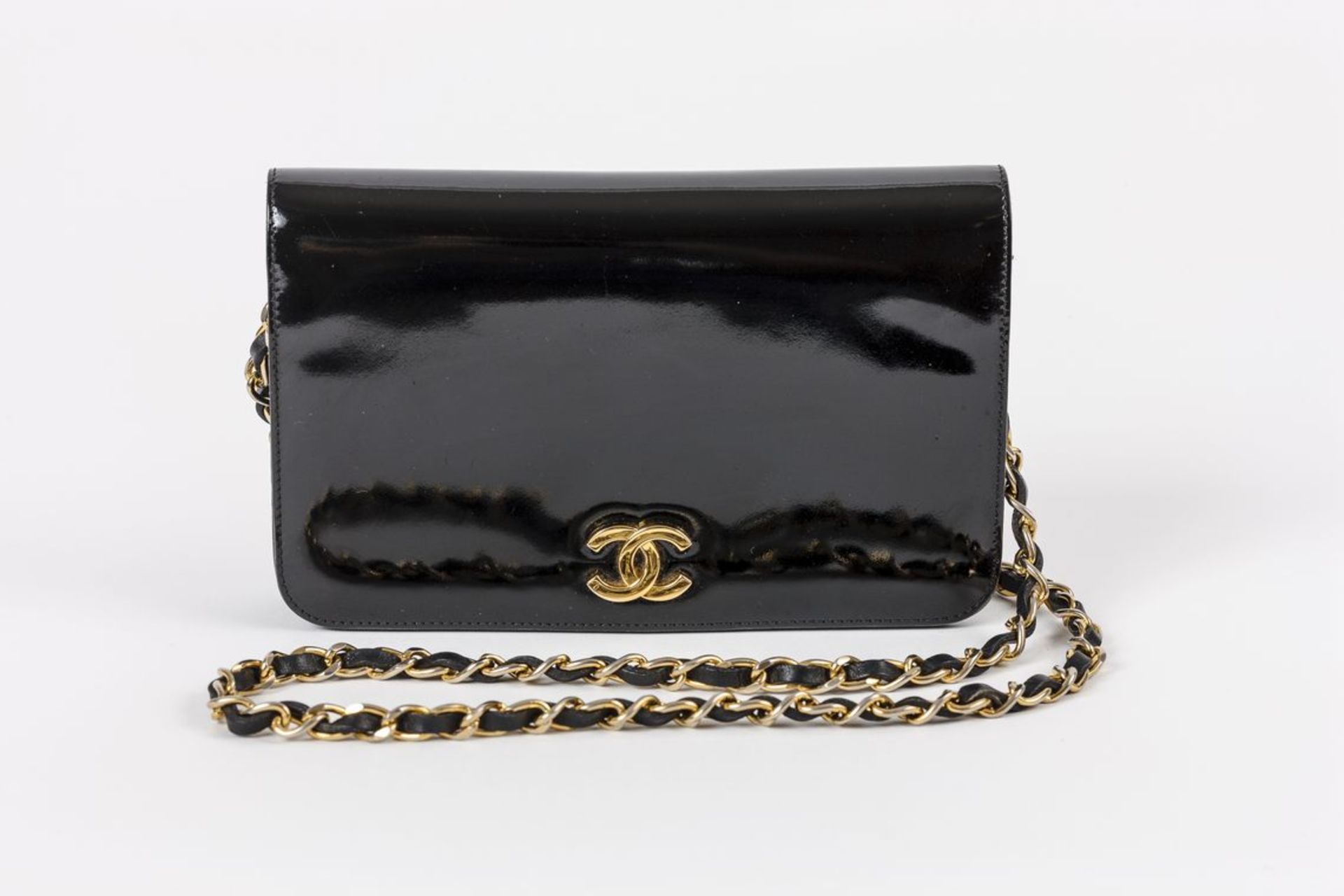 Chanel DamenhandtascheFlap-Bag in schwarzem Lack mit dekorativem Metallverschluss aus goldenem