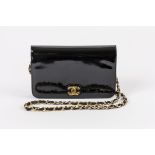 Chanel DamenhandtascheFlap-Bag in schwarzem Lack mit dekorativem Metallverschluss aus goldenem