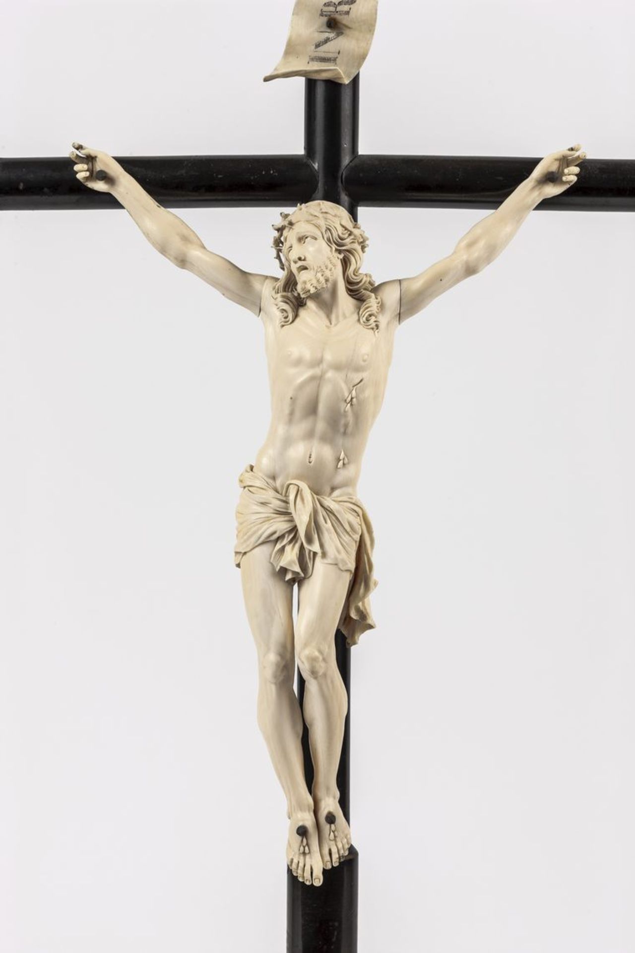 KruzifixStandkreuz aus ebonisiertem Holz, daran leidender Christus im Viernageltypus sowie INRI-