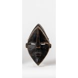 Afrikanische MaskeHolz, geschnitzt, dunkelbraun patiniert (Farbabsplitterungen). Spitzovales Gesicht