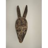 Afrikanische TiermaskeHolz, geschnitzt, farbig gefasst. Stilisierte Tiermaske mit zwei großen
