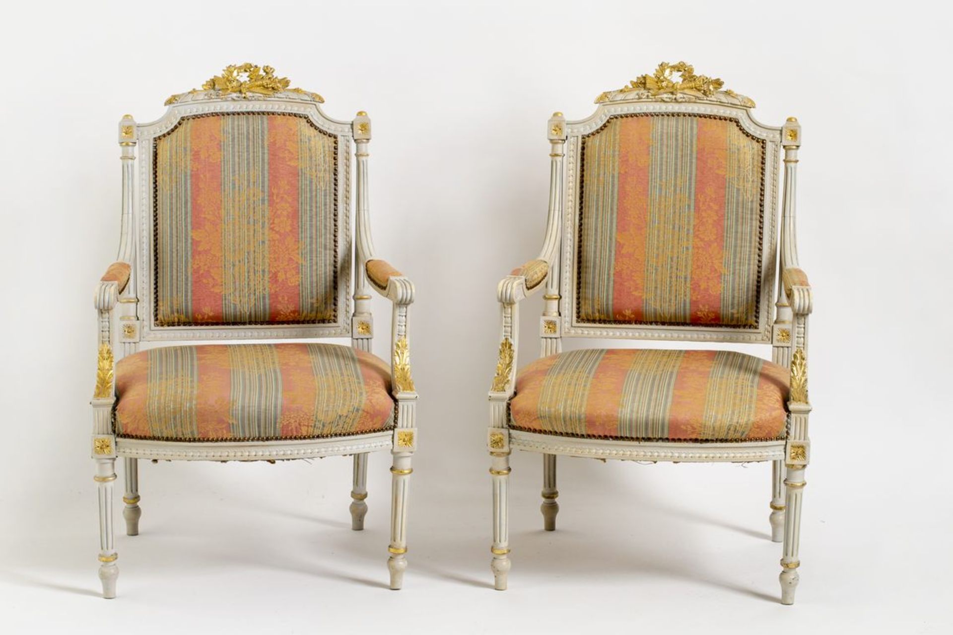 Paar Louis-Seize-SesselBeige gefasst, goldgehöhte Reliefs und Bekrönungen. Gepolsterte Sitzfläche,