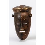 Afrikanische GesichtsmaskeHolz, geschnitzt, in zwei Brauntönen gefasst (Farbabsplitterungen).