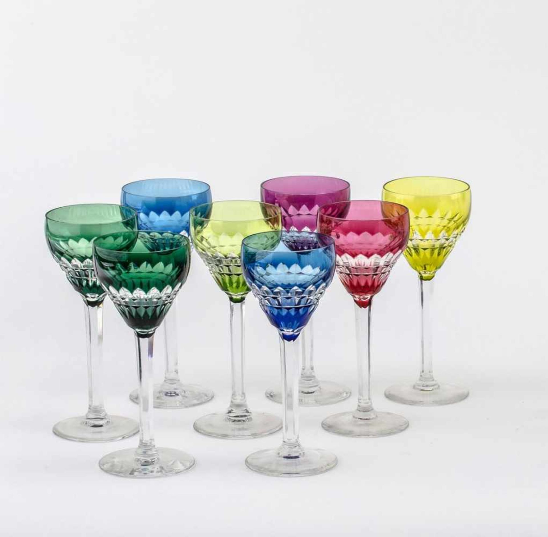 Acht SüdweinrömerKristallglas. Runder Stand, facettierter Schaft, glockenförmige, farbig überfangene