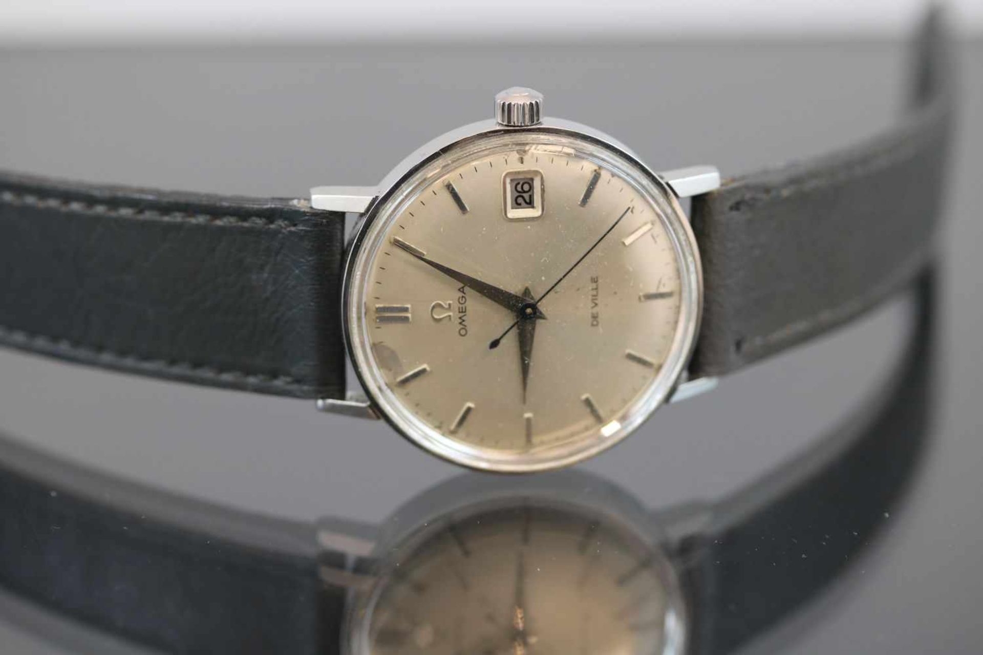 Omega- UhrWerk: AutomatikBand: Graues LederbandFunktion: Datum-SekundenanzeigerGehäuse Ø: 3,5 cm