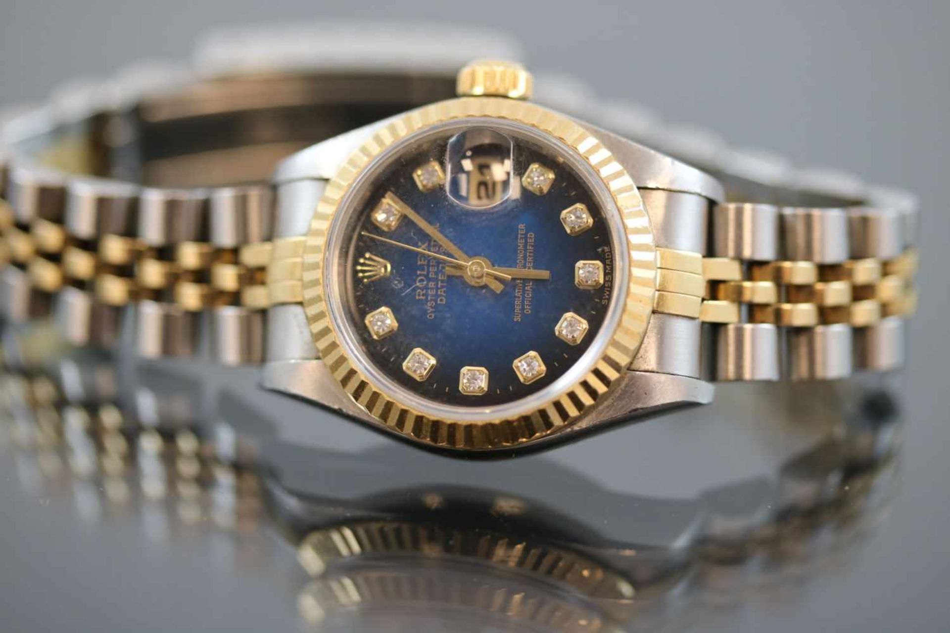 Rolex Oyster PerpetualWerk: AutomatikBand: Stahl/GoldFunktion: DatumsanzeigeGehäuse Ø: 2,6 cm Blaues
